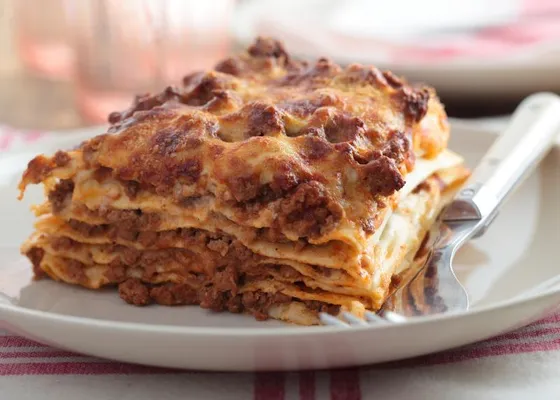A baked square of lasagna with meat sauce and a browned cheese surface