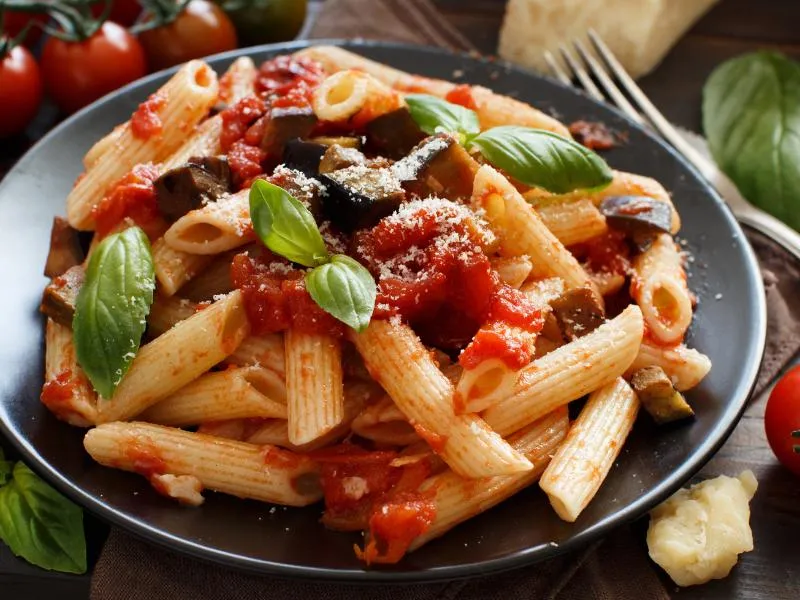 Short tube pasta with tomato sauce, eggplant, grated cheese and basil