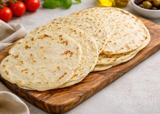A stack of thin round flatbreads with brown griddle marks