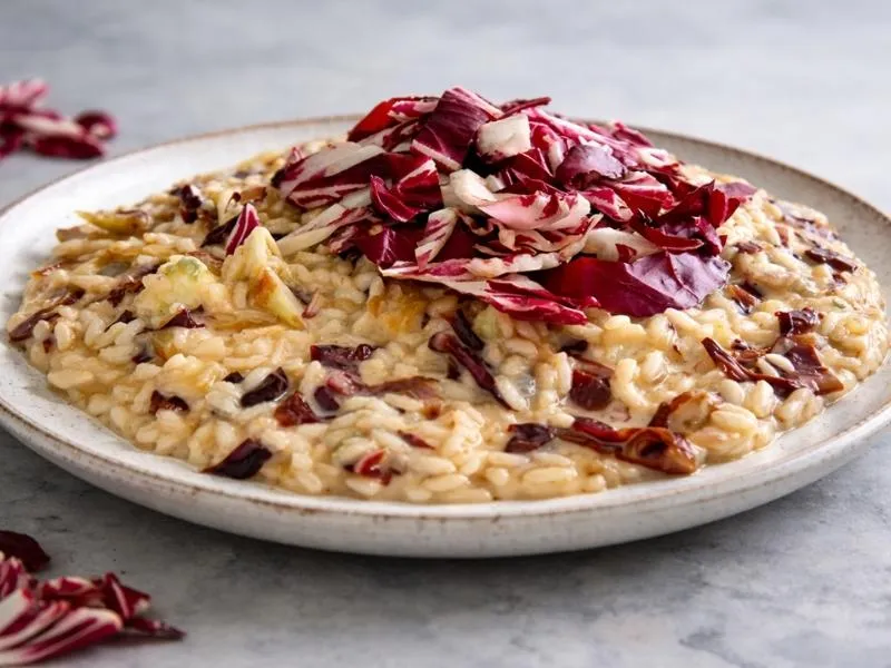 Creamy risotto flecked with cooked red radicchio and topped with a mound of fresh burgundy and white radicchio strips