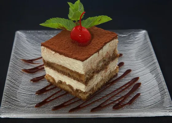 A serving of tiramisù with cocoa-dusted mascarpone cream and coffee-soaked biscuit layers